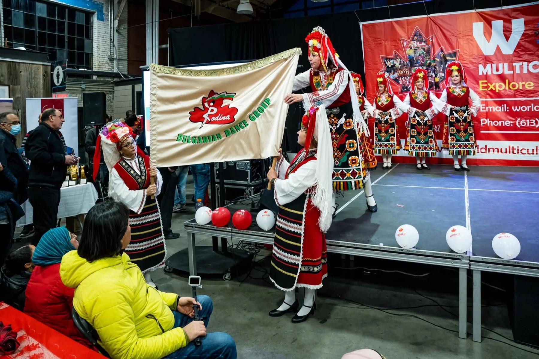 Rodina dancers carrying the ensemble's official banner onto the World Multicultural Festival stage
