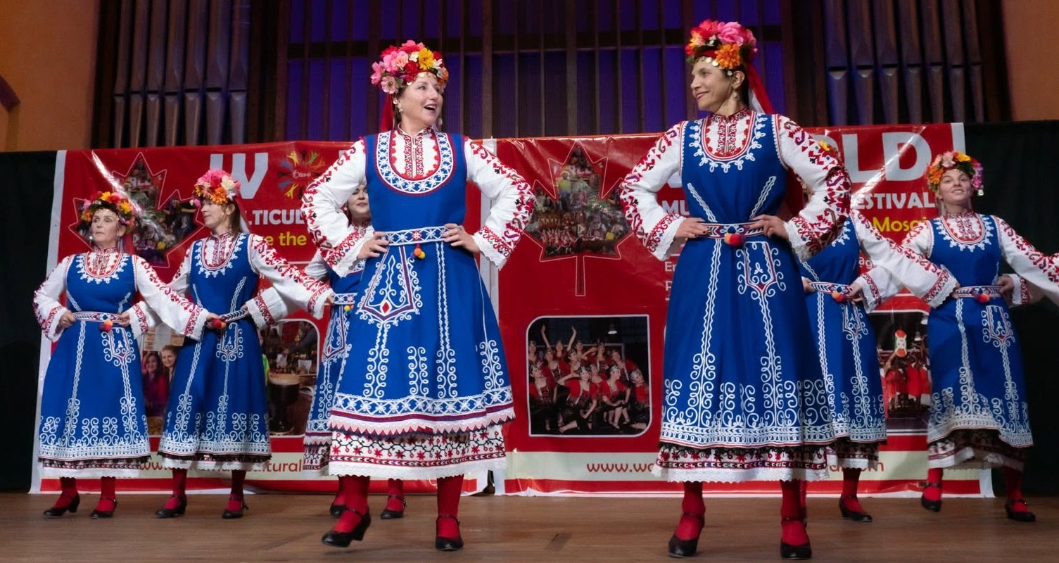 Rodina dancers in blue Bulgarian folk costumes performing in formation on the World Multicultural Festival stage