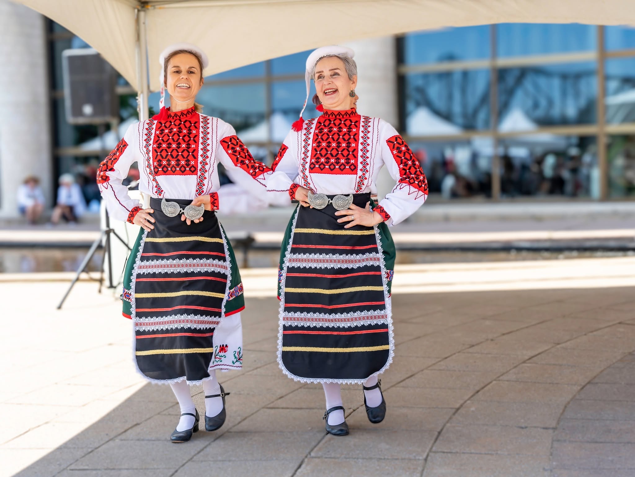 Two Rodina dancers performing together in Bulgarian folk costumes at the 2025 EU Cultural Fair